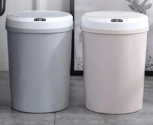 Two electric smart trash cans, one gray and one beige, on a tiled floor.