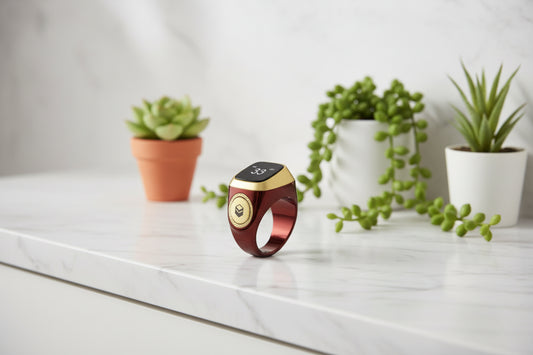 Gold and red smart ring with digital display on a white background