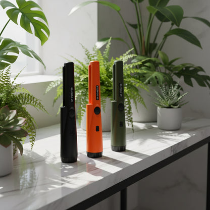 Three G.P. Pointer devices in black, orange, and green on a white background