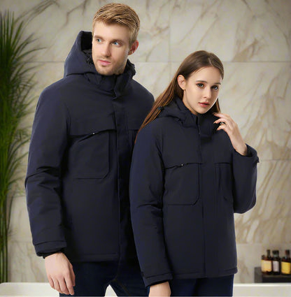Two people wearing matching dark blue winter coats against a neutral background.