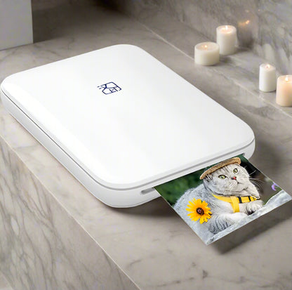 White portable photo printer with a printed photo of a cat wearing a hat and sunflower.