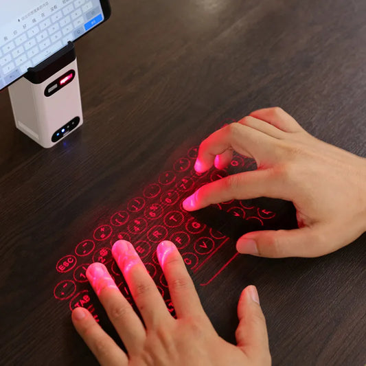Hands typing on a red laser projected keyboard on a dark surface.