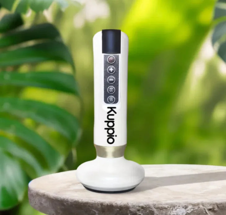 White and black device with 'Kuppio' branding on a stone surface with green foliage in the background