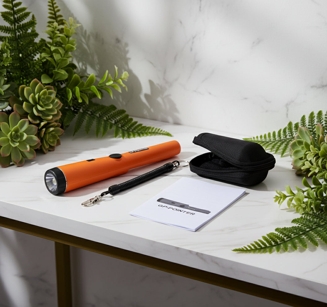 Orange metal detector with black case, lanyard, and user manual on a white background