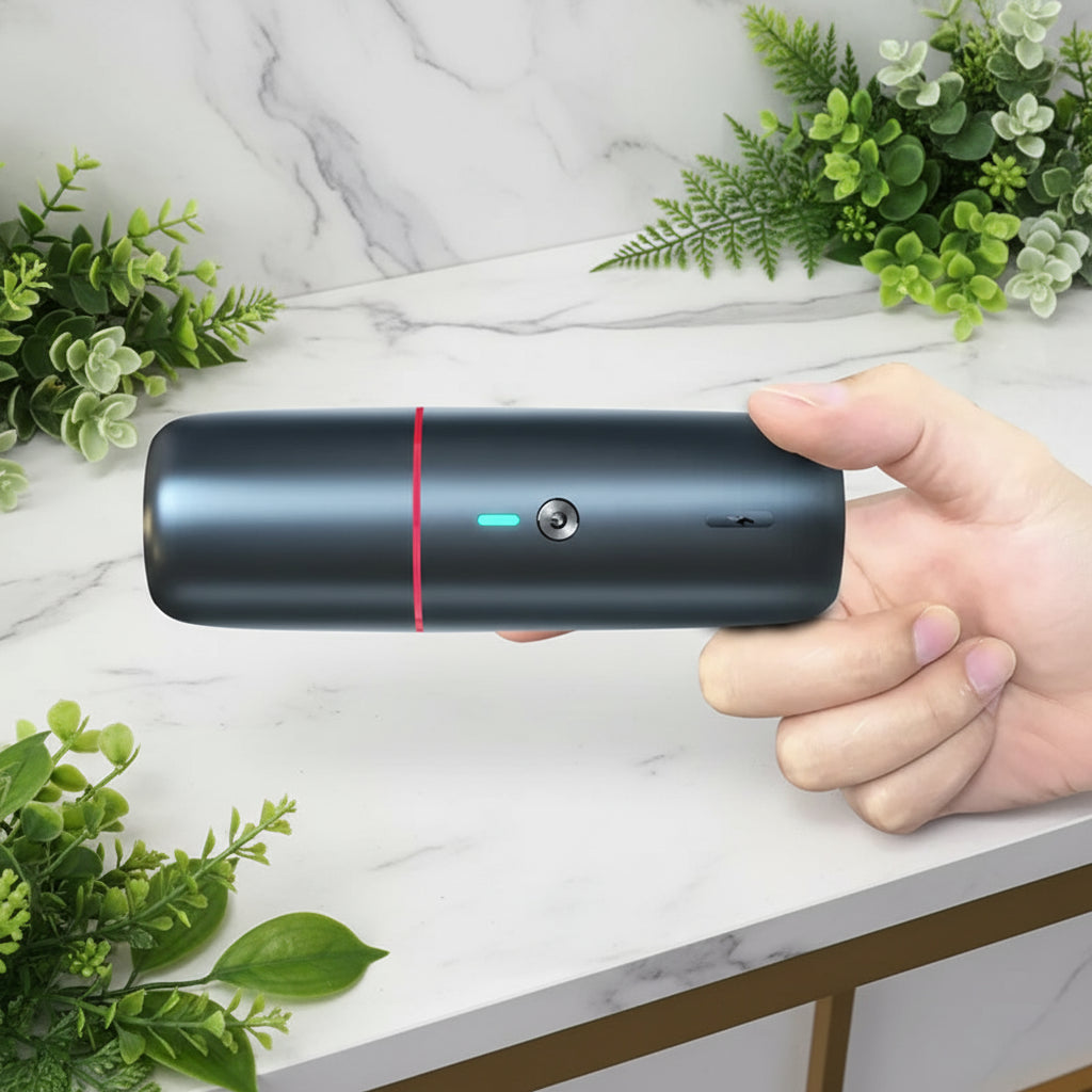 Hand holding a cylindrical black device with a red line on a white background