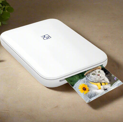 White portable photo printer with a printed photo of a cat wearing a hat and sunflower.