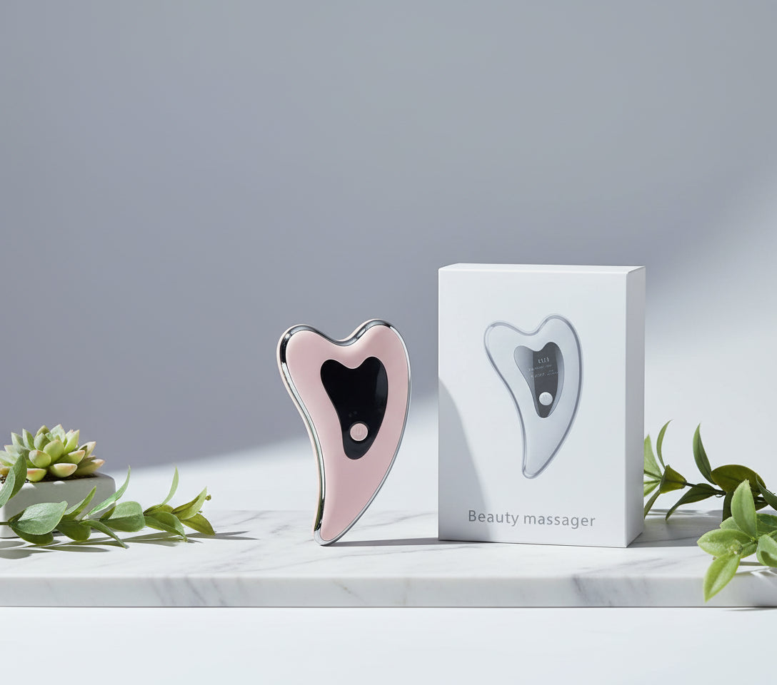 Heart-shaped beauty massager in packaging with a red arrow pointing to it.