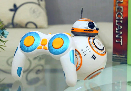 Toy robot resembling BB-8 from Star Wars on a reflective surface with a blurred background