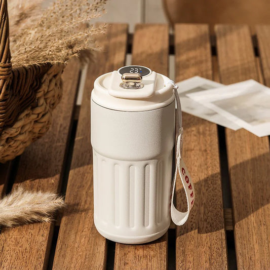 White thermos with digital display on a wooden surface